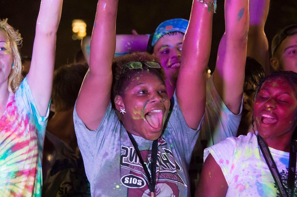 Young girls with glow paint splashes cheering at a student activities event