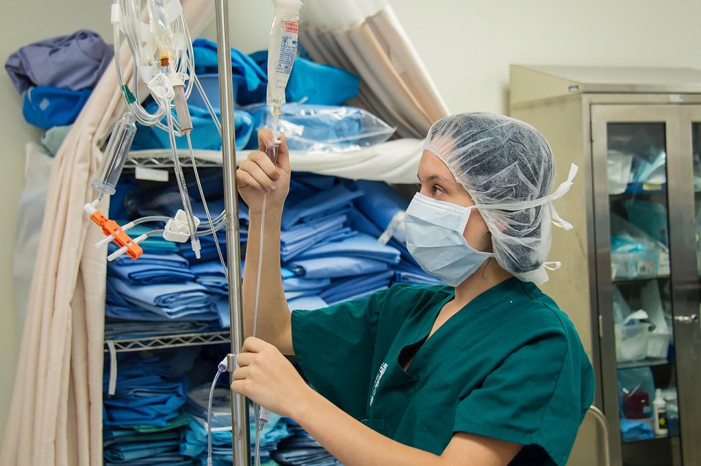 A surgery student preparing an intravenous line 