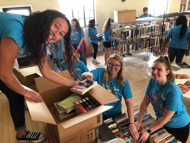 Day of Caring volunteers putting books into boxes