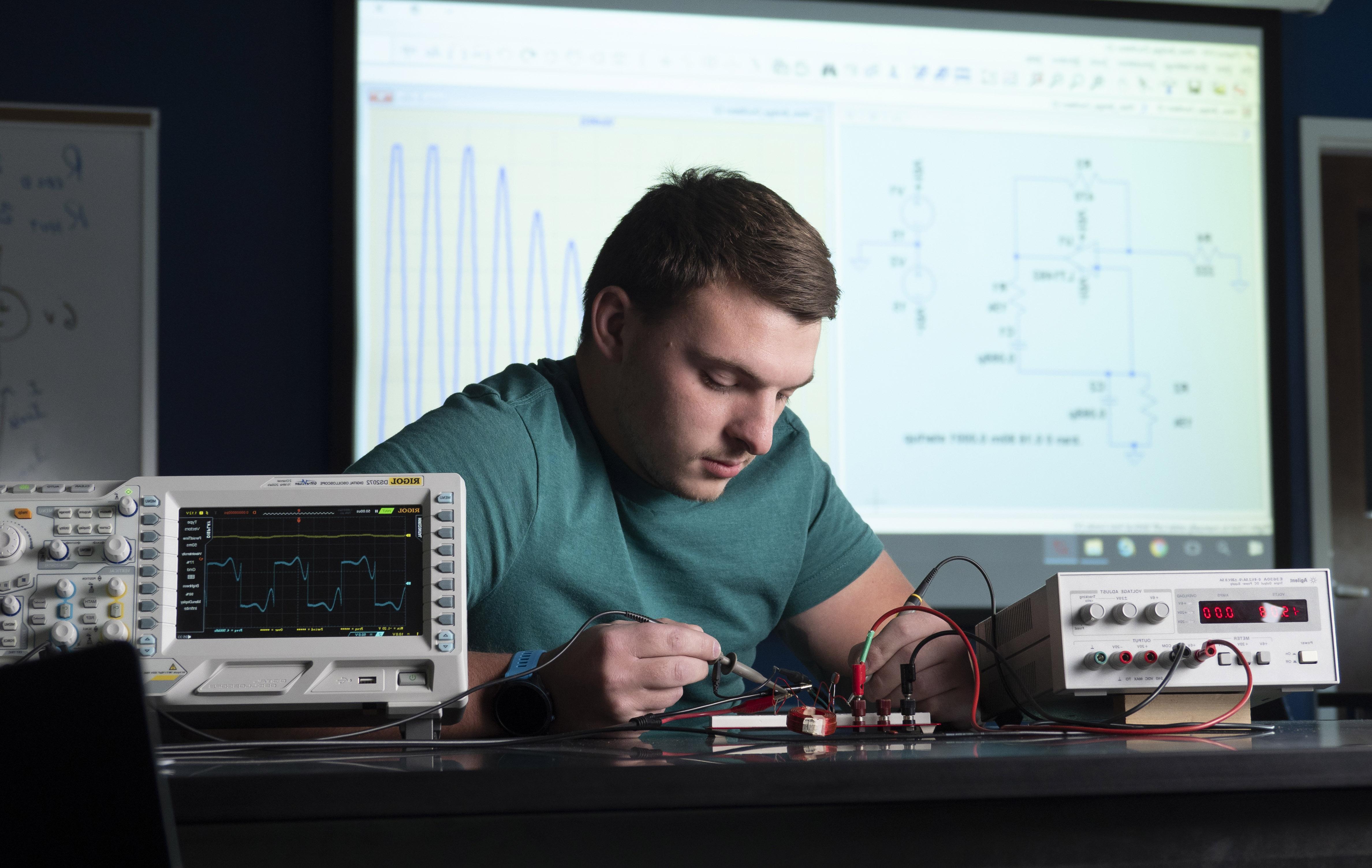 An engineering student connecting wires to a board
