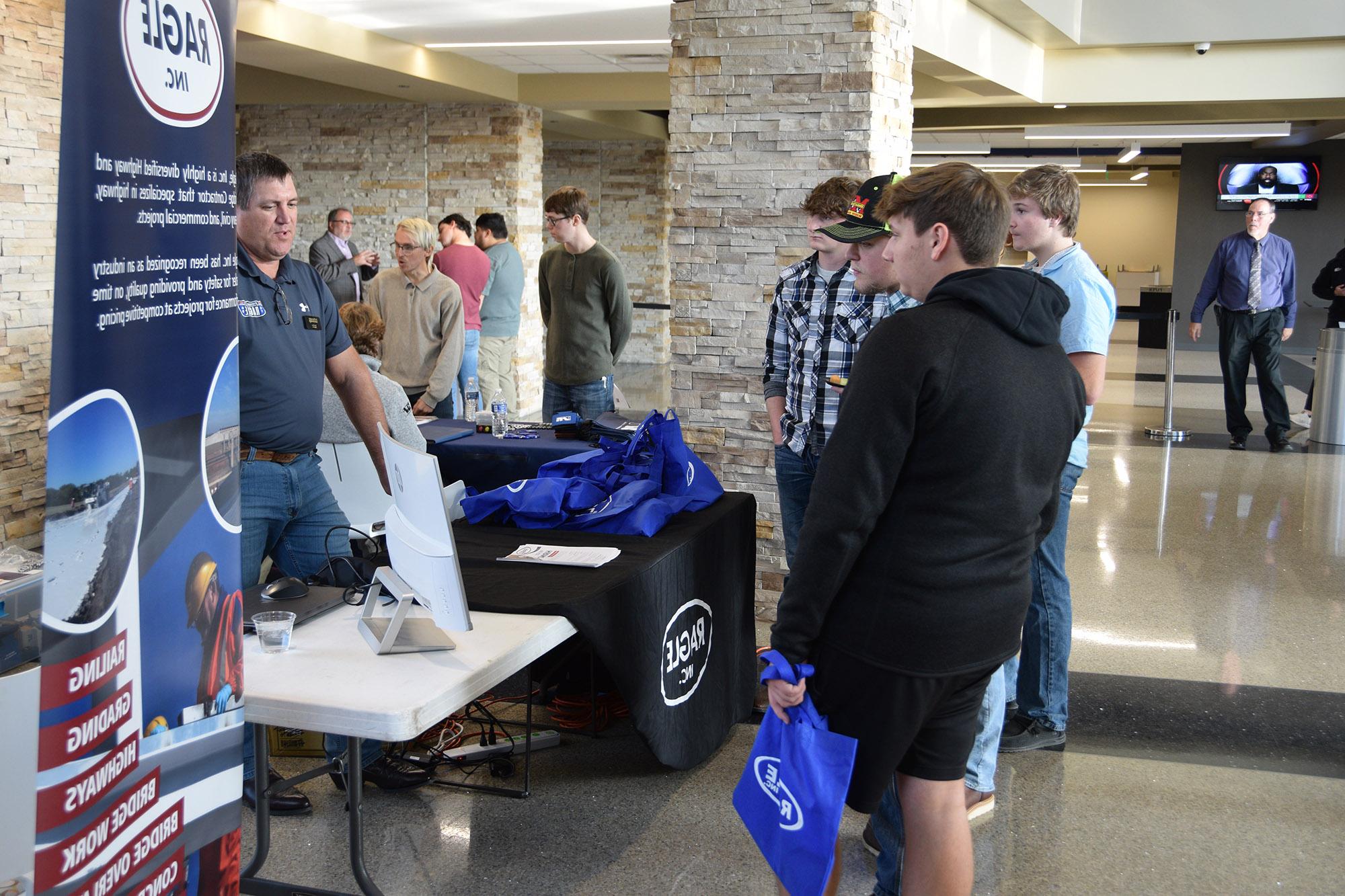 A group of students talking to a potential employer at a job fair in Jefferson Student Union