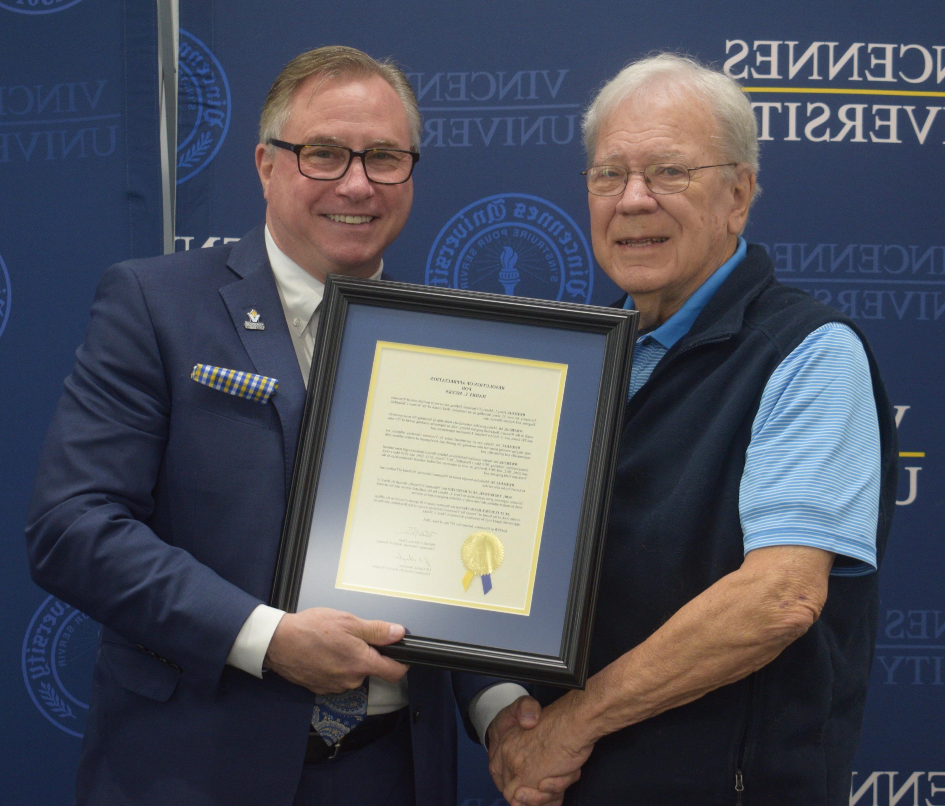 Harry Meeks (left) receives a Resolution of Appreciation from Dr. Chuck Johnson and the Board of Trustees.